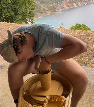 Male student working on a piece of pottery