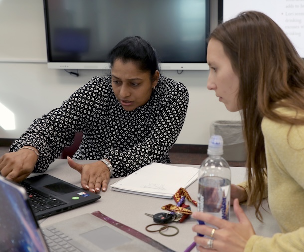 Female faculty showing a female student a laptop