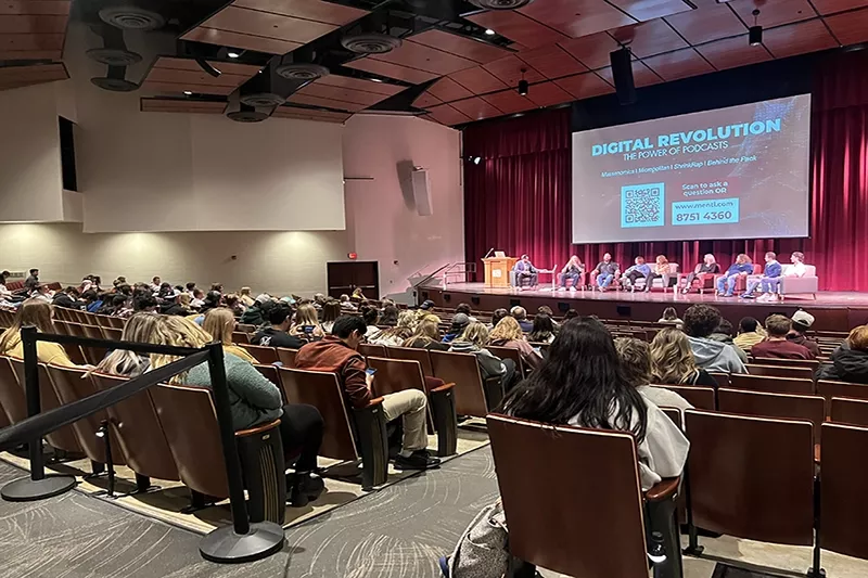 People attend a presentation titled "Digital Revolution the Power of Podcasts"